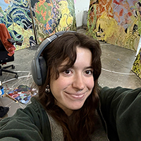 Woman with headphones close-up with a backdrop of paintings