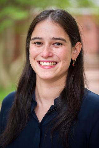 woman with long dark hair smiling at the viewer