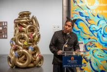 Handsome young man giving a talk in front of an art instillation